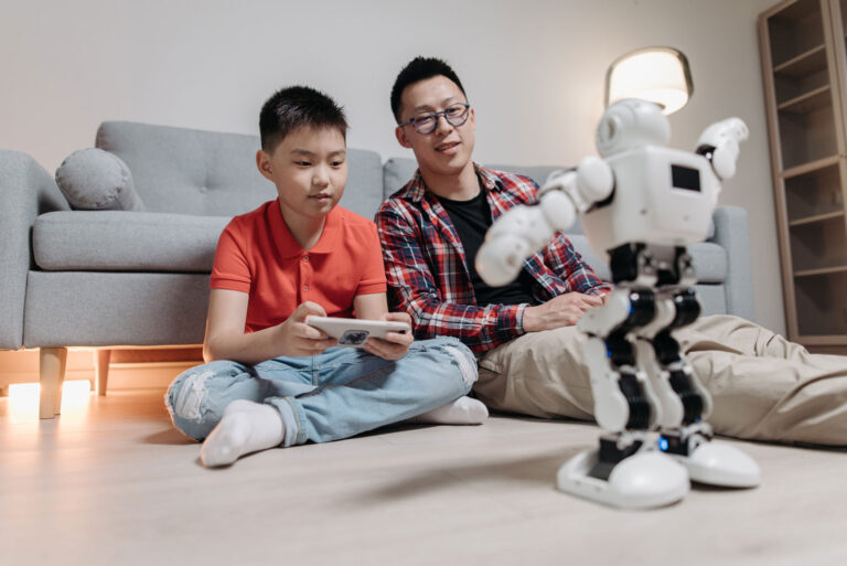 Asian father and son playing with robot, Autism Assessments in McKinney, TX