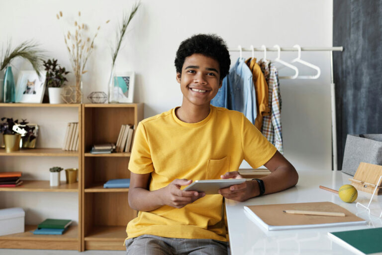 young man smiling at camera while at desk, neuropsychological testing in McKinney, TX